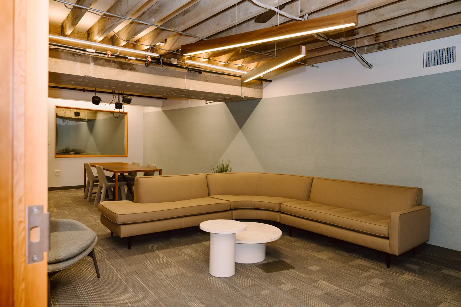 Lower-level lounge with sectional sofa and mounted screen