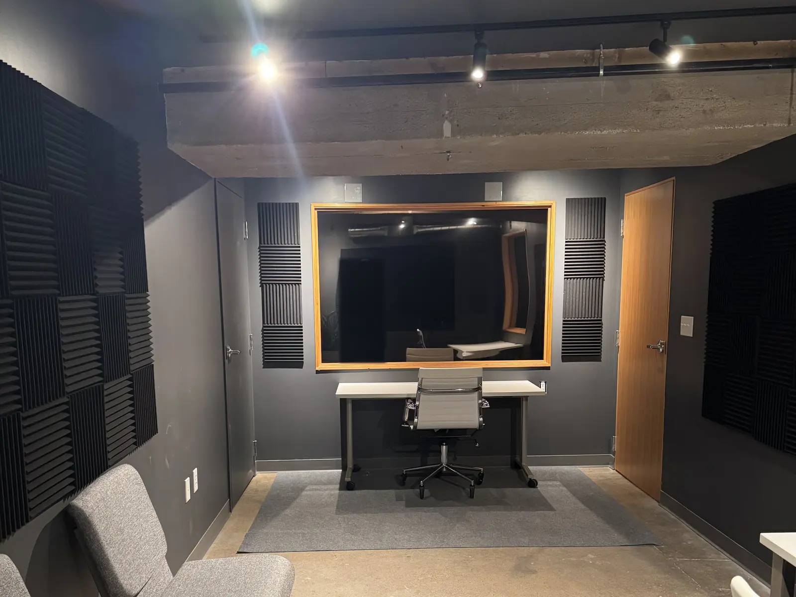Lower-level research room with acoustic panels and a large interior window