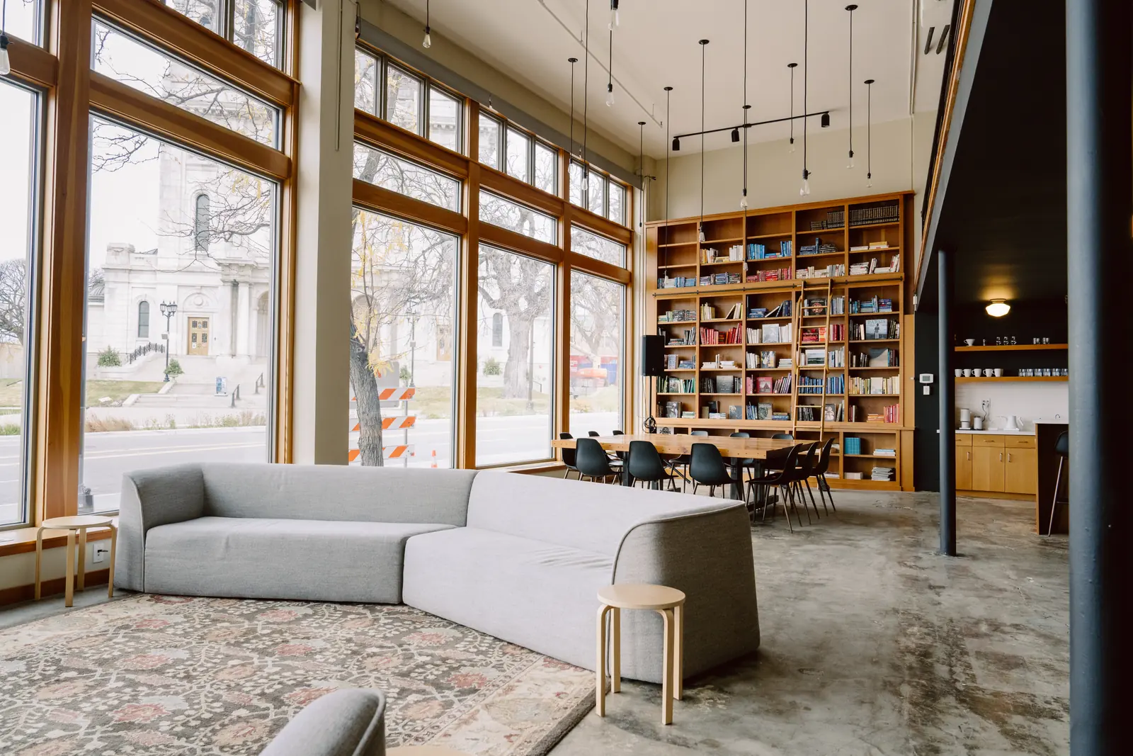 Basecamp's main floor with lounge seating, floor-to-ceiling windows and a two-story library wall