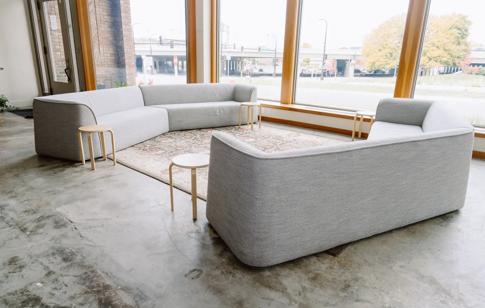Lounge area with curved sofas beside large windows