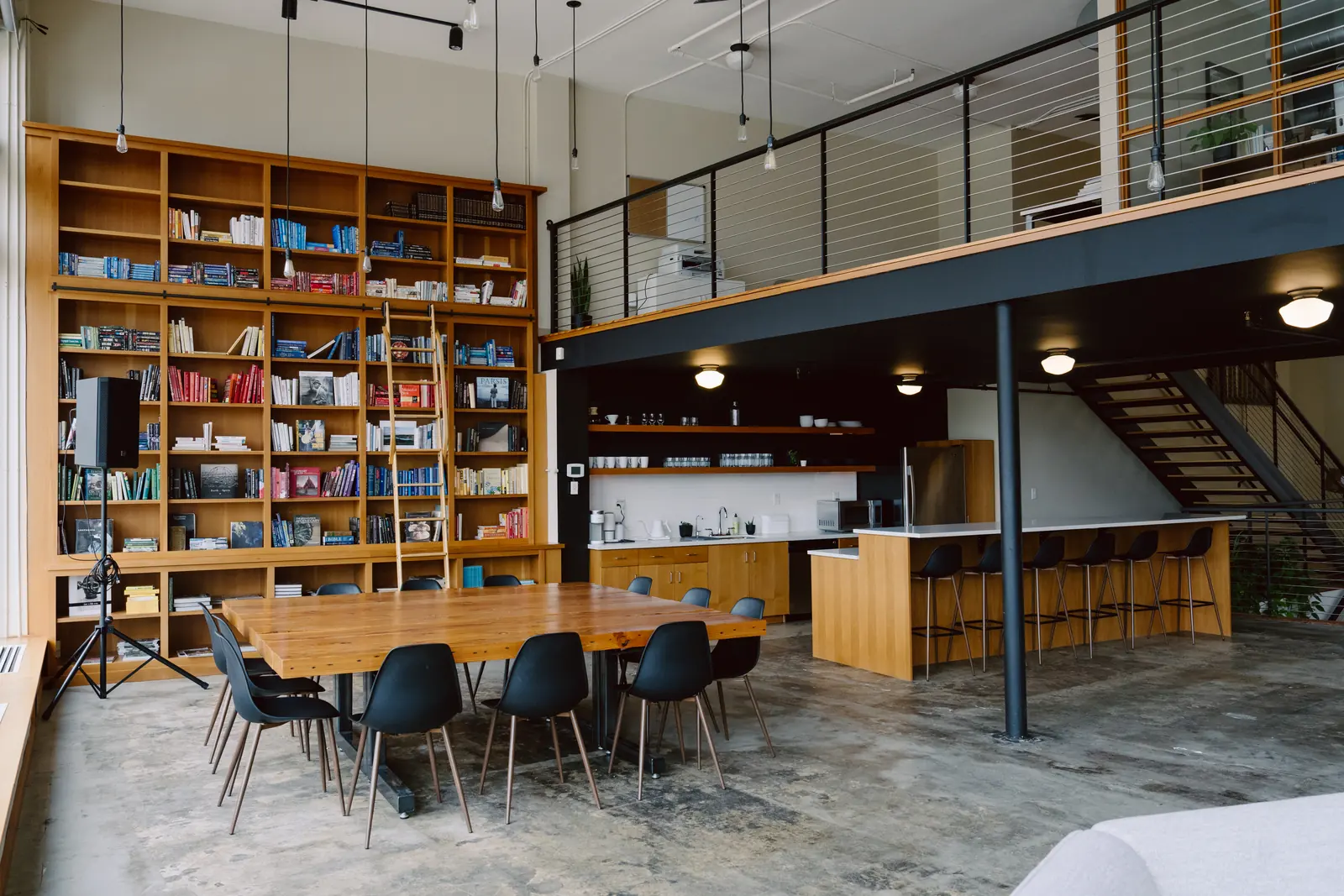 Communal table, library wall and mezzanine at Basecamp